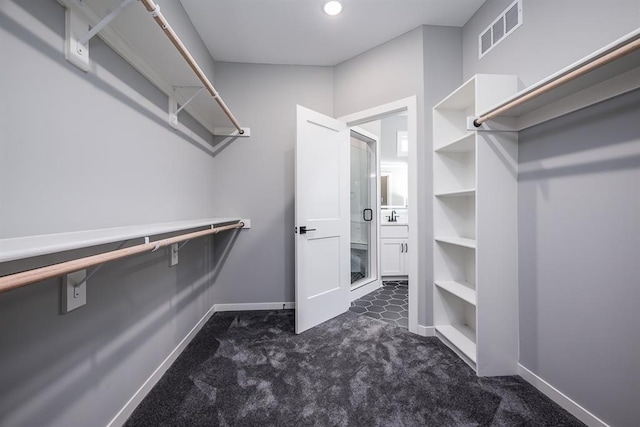 walk in closet featuring visible vents and dark carpet