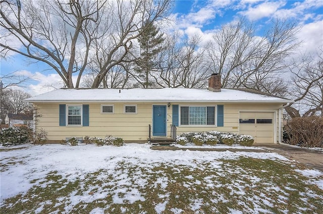 ranch-style home with an attached garage, driveway, and a chimney