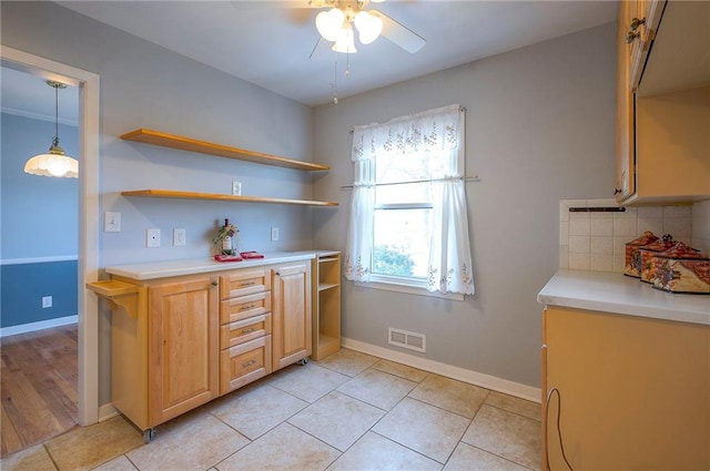 kitchen featuring light countertops, visible vents, backsplash, and baseboards