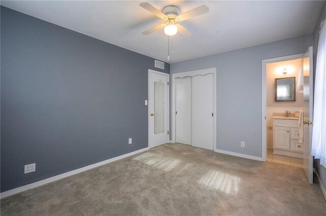 unfurnished bedroom with ensuite bathroom, visible vents, baseboards, a closet, and carpet