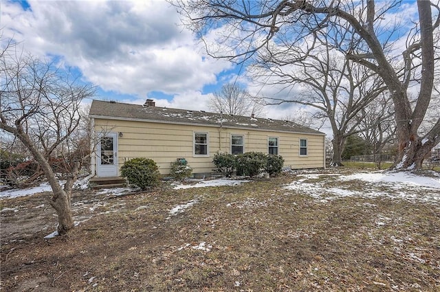 snow covered back of property featuring entry steps