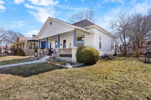 bungalow with covered porch, central AC, and a front yard