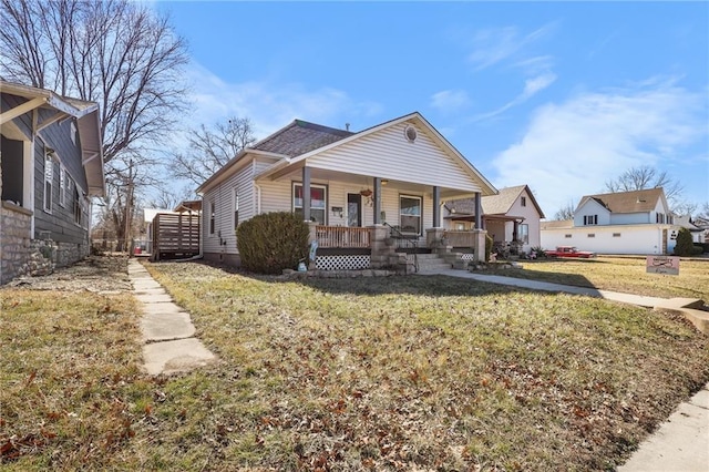 bungalow-style home with a front yard and covered porch