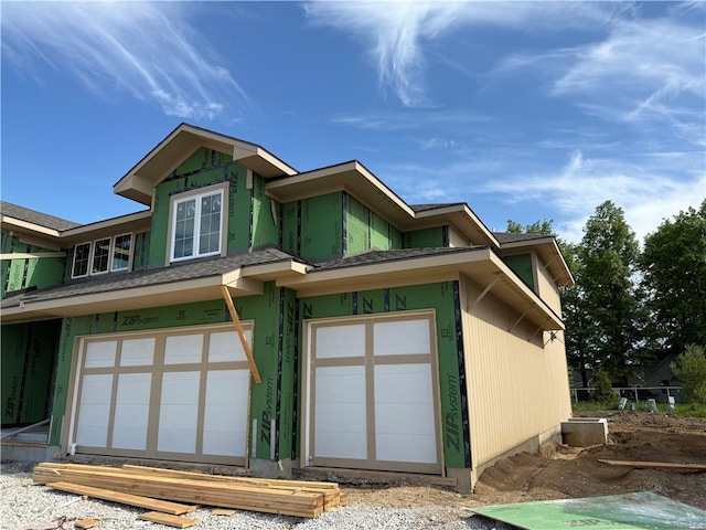 view of front of house featuring roof with shingles and a garage