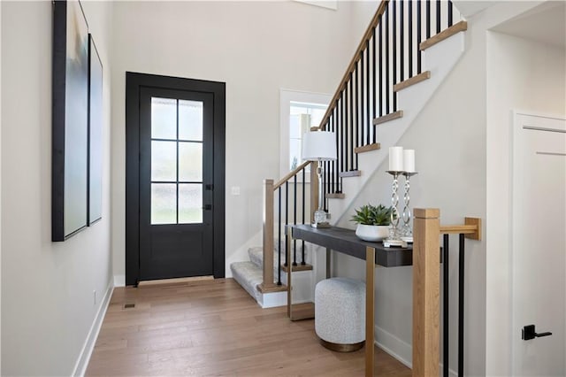 entrance foyer featuring wood finished floors, stairway, and baseboards