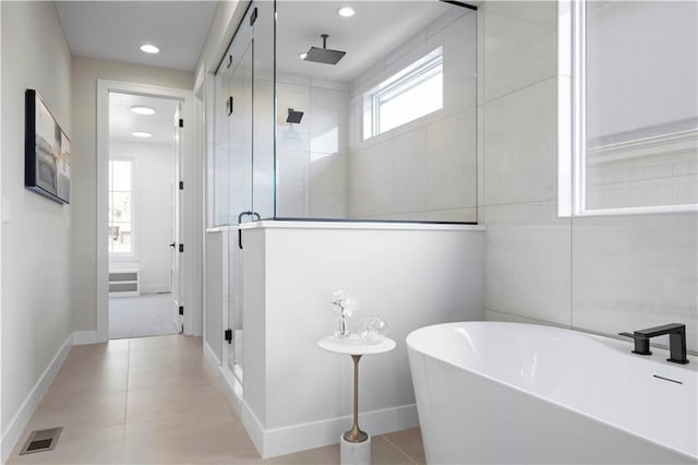 full bathroom with a stall shower, a soaking tub, baseboards, tile patterned flooring, and recessed lighting