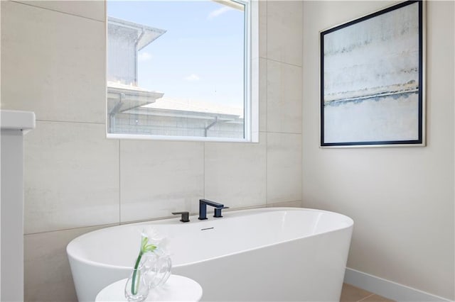 bathroom with a freestanding bath and baseboards