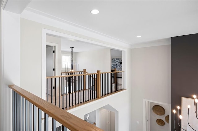 hallway featuring an upstairs landing, a chandelier, a high ceiling, recessed lighting, and crown molding