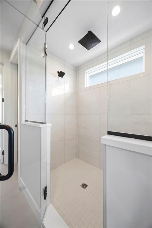 full bath with a stall shower, recessed lighting, and tile patterned floors