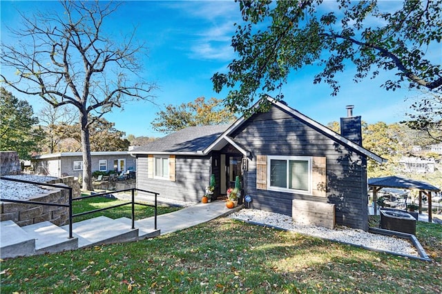 view of front of property featuring a front lawn and a chimney