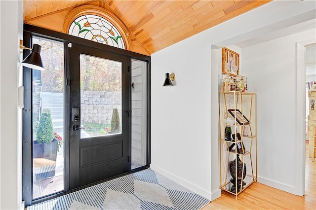 foyer entrance with lofted ceiling, wooden ceiling, baseboards, and wood finished floors