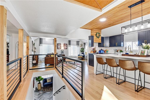 kitchen featuring light wood finished floors, a breakfast bar area, light countertops, and a wealth of natural light