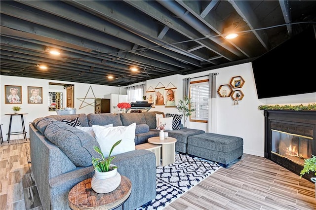 living room featuring wood finished floors and a glass covered fireplace