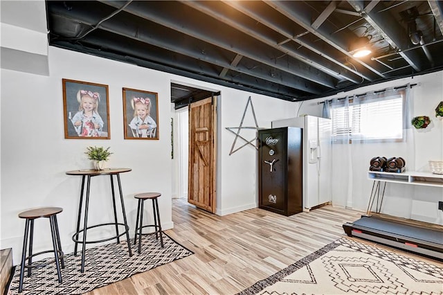 exercise room featuring light wood-style floors and a barn door