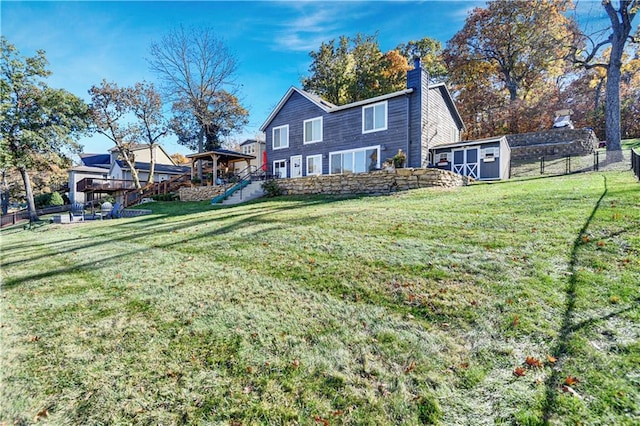 rear view of house featuring a shed, a lawn, a playground, and an outbuilding