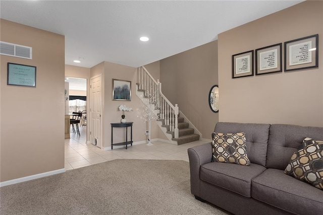 carpeted living area with tile patterned floors, baseboards, visible vents, and stairway