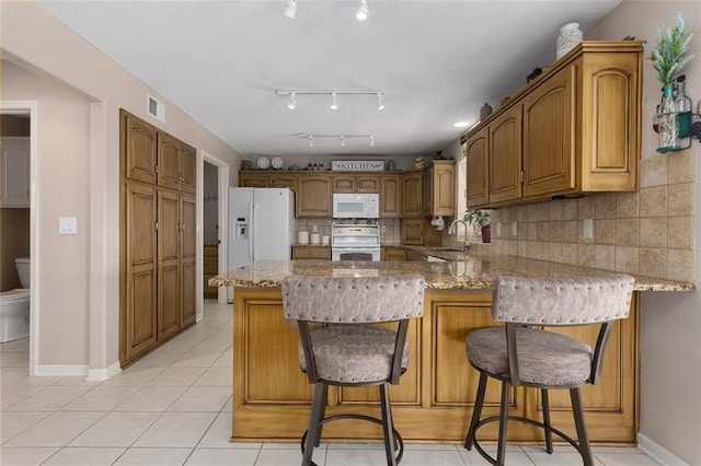 11319 Easley Dr, Lees Summit, MO 64086 - kitchen with white appliances, a peninsula, a sink, tasteful backsplash, and light tile patterned flooring
