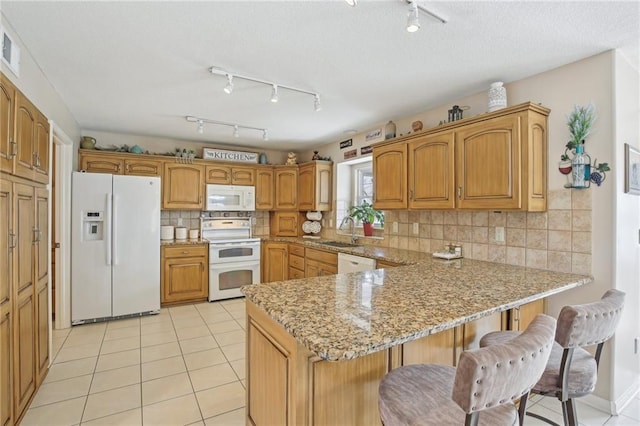 11319 Easley Dr, Lees Summit, MO 64086 - kitchen with white appliances, a peninsula, a sink, track lighting, and a breakfast bar