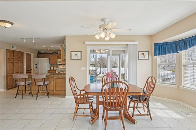 dining area with baseboards, a ceiling fan, visible vents, and light tile patterned floors