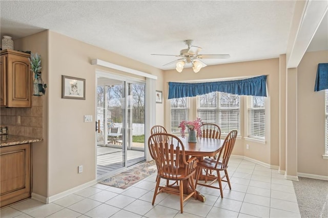 dining area featuring a ceiling fan, baseboards, a textured ceiling, and light tile patterned flooring