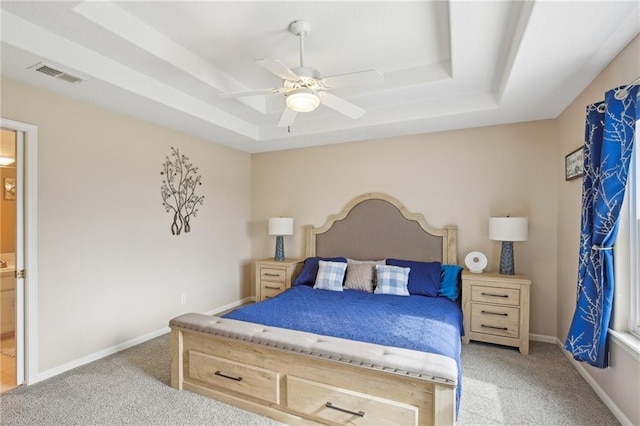 bedroom featuring a raised ceiling, visible vents, baseboards, and light carpet