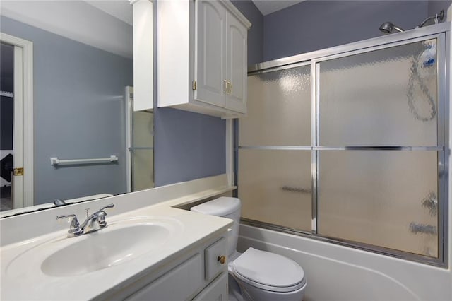 bathroom with bath / shower combo with glass door, toilet, and vanity
