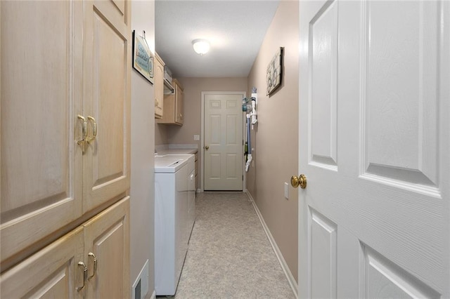 clothes washing area with baseboards, cabinet space, washer and clothes dryer, and visible vents