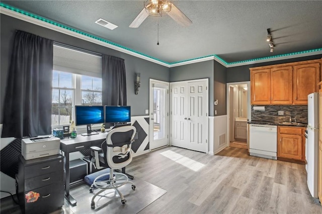 home office featuring a textured ceiling, light wood-style flooring, visible vents, and a ceiling fan