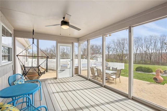 sunroom / solarium featuring a ceiling fan and outdoor dining space