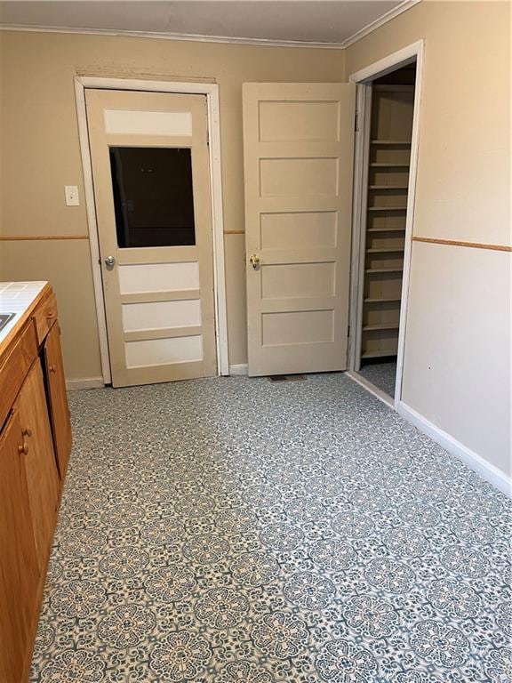 interior space featuring baseboards and crown molding