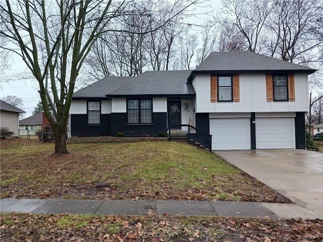 split level home with a front lawn, roof with shingles, driveway, and an attached garage