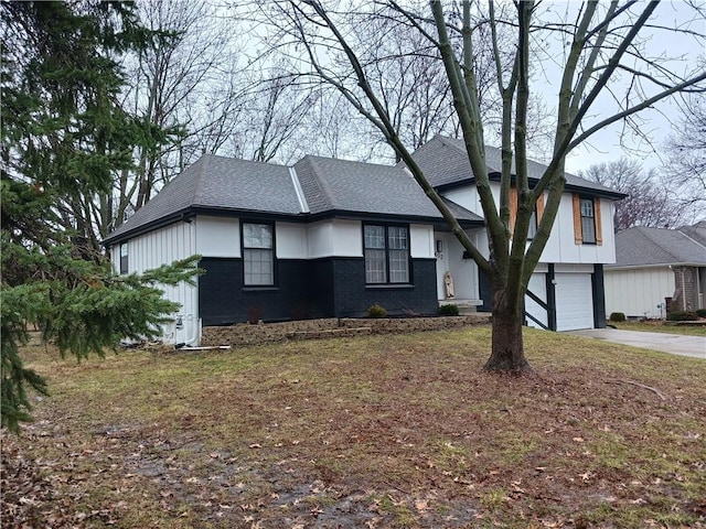 view of front of house with driveway, an attached garage, roof with shingles, and brick siding