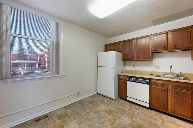 314 N 6th St, Leavenworth, KS 66048 - kitchen featuring visible vents, light countertops, a sink, a textured ceiling, and white appliances