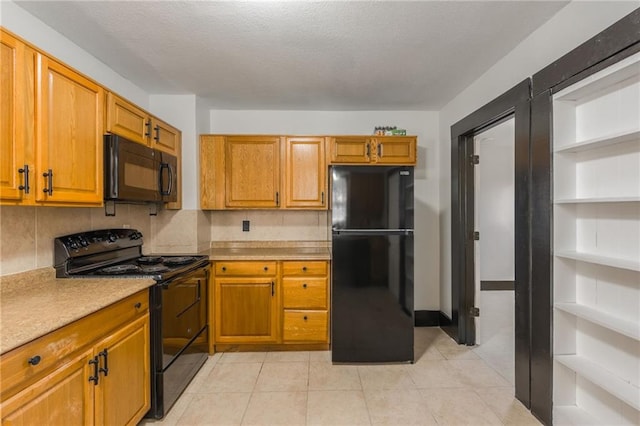 kitchen with brown cabinets, black appliances, a textured ceiling, tasteful backsplash, and light countertops