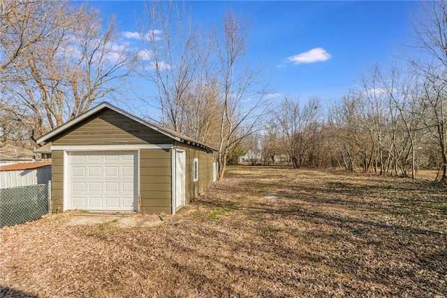 detached garage featuring fence