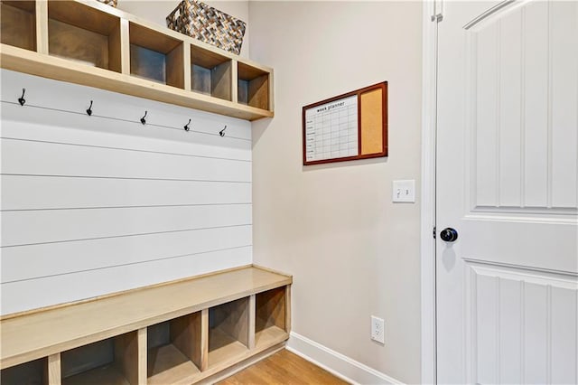 mudroom featuring light wood finished floors and baseboards