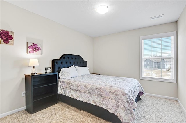 bedroom featuring visible vents, baseboards, and light colored carpet