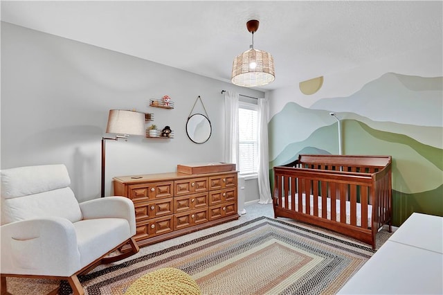 bedroom featuring carpet flooring and a nursery area