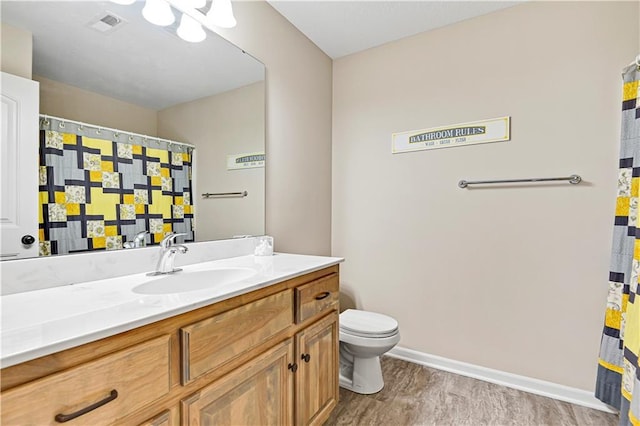 full bathroom featuring visible vents, baseboards, toilet, wood finished floors, and vanity