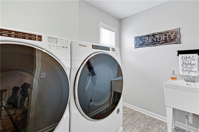 washroom featuring laundry area, baseboards, and washing machine and clothes dryer