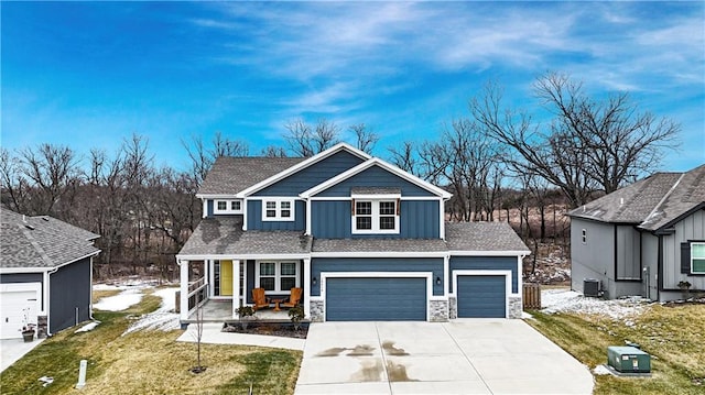 view of front of home featuring stone siding, board and batten siding, concrete driveway, and a garage