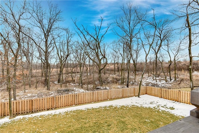 snowy yard with a fenced backyard