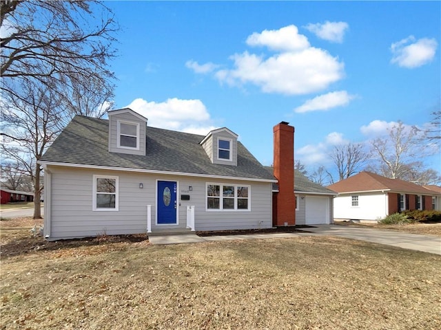 view of front facade with an attached garage, a chimney, concrete driveway, and roof with shingles