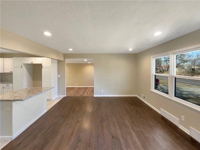 interior space featuring recessed lighting, wood finished floors, visible vents, and baseboards