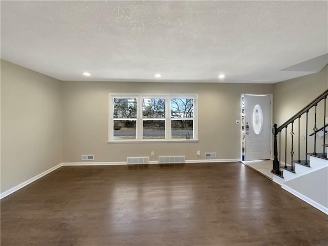 entrance foyer with stairs, visible vents, and baseboards