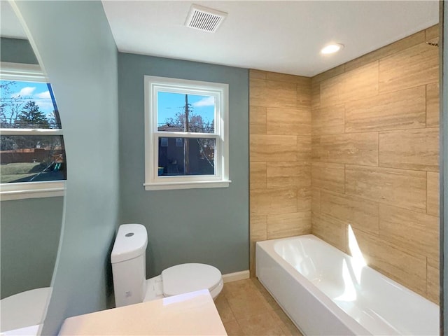 full bathroom with tile patterned flooring, toilet, visible vents, baseboards, and a bath