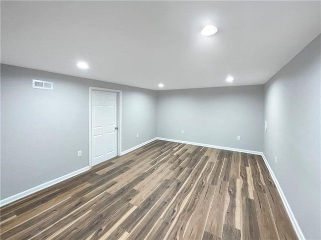 finished basement with dark wood-type flooring, recessed lighting, visible vents, and baseboards