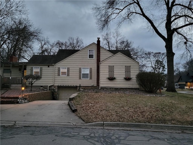 view of front of house with a garage, driveway, and a chimney