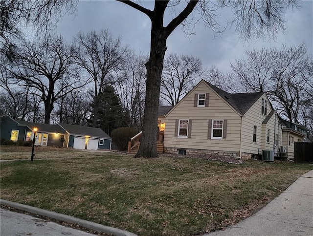 view of front facade with a garage, cooling unit, and a front yard