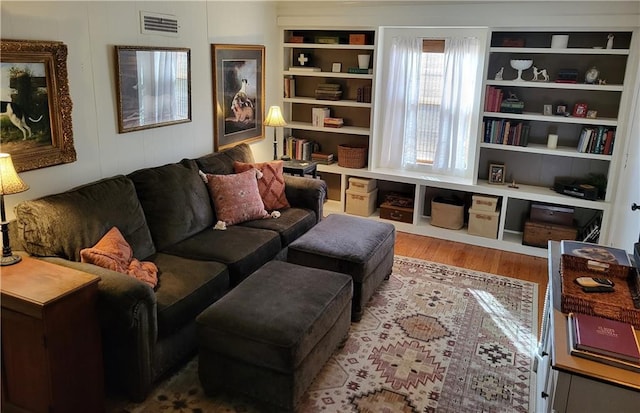 living area featuring wood finished floors and visible vents